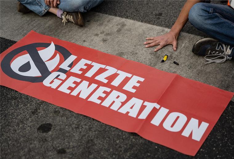 Mit Kleister und Plakaten bewaffnet: Die „Letzte Generation“ beklebt die Bremische Bürgerschaft Ein Transparent mit dem Logo der "Letzten Generation".