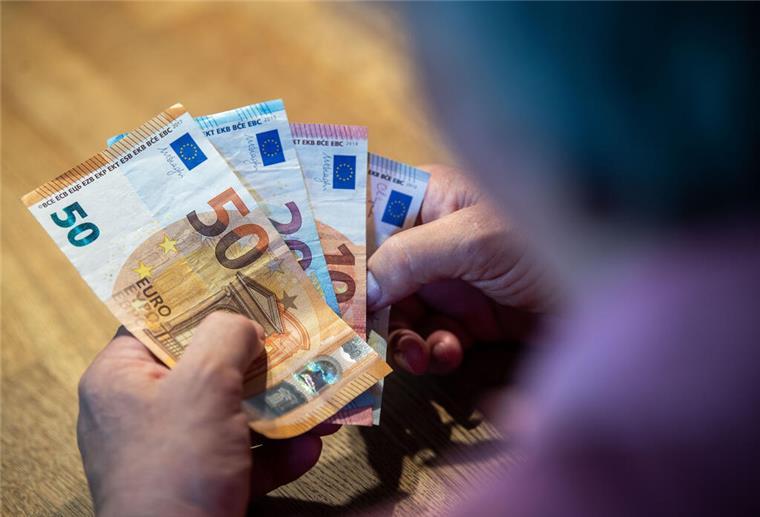Finanzielle Lücke im Alter befürchtet - Mehrheit sorgt sich Ein älterer Mann sitzt an einem Tisch und zählt Geld.