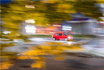 Rotes Auto fährt mit Licht auf der Straße, Nachtaufnahme.