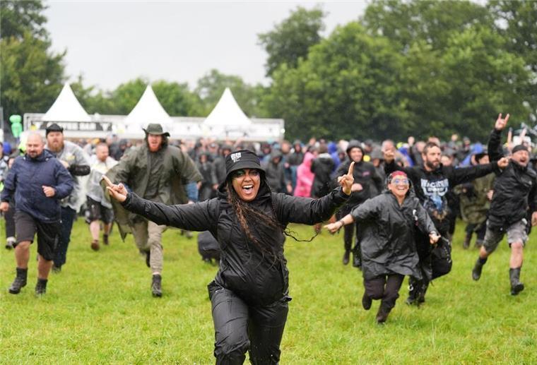 Metalfans nehmen nasses Infield in Wacken ein Die Menschen freuen sich auf die ersten Konzerte.