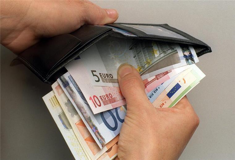 Ein Mann verstaut einige Euro-Geldscheine in seiner Geldbörse. Miete kaum bezahlbar? Wohngeld kann Haushalte deutlich entlasten. 
