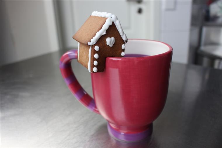 Die Mini-Version eines Lebkuchenhauses, macht es sich am Tassenrand gemütlich.