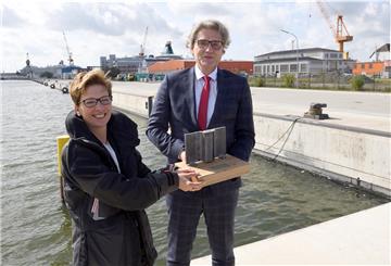 Die neue Kaje ist fertig. Bremenports-Chef Robert Howe schenkt Häfensenatorin Dr. Claudia Schilling ein kleines Stückchen Spundwand.