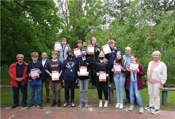 Die neuen Schulbusbegleiter der Zinzendorfschule präsentieren zusammen mit Vertretern der Verkehrsbetriebe sowie des Landkreises und der Schule ihre Zertifikate. Sie können nun in den Einsatz gehen.