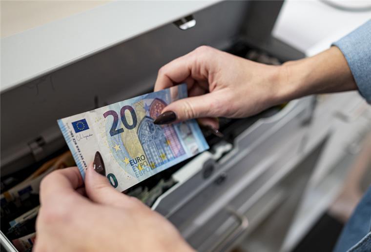 Umfrage: Die Deutschen zahlen am liebsten mit Bargeld Eine Mitarbeiterin legt Geld in die Kasse