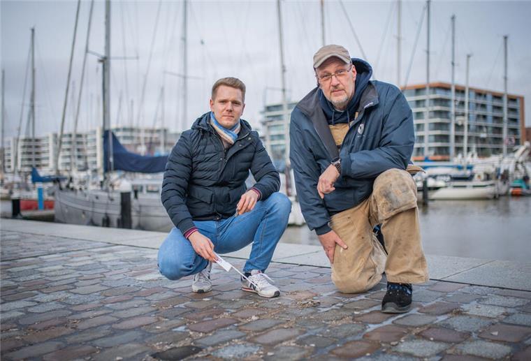 Die Oberfläche der Fugen bröckelt an vielen Stellen am Neuen Hafen. Projektleiter Tim Thyen von der Bremerhavener Entwicklungsgesellschaft Alter/ Neuer Hafen (links) lässt sich die Schäden von „Im Jaich“- Haustechniker Lars Fröhlich zeigen.