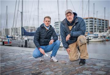 Die Oberfläche der Fugen bröckelt an vielen Stellen am Neuen Hafen. Projektleiter Tim Thyen von der Bremerhavener Entwicklungsgesellschaft Alter/ Neuer Hafen (links) lässt sich die Schäden von „Im Jaich“- Haustechniker Lars Fröhlich zeigen.