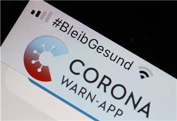 Die offizielle Corona-Warn-App ist auf einem Smartphone zu sehen, darüber steht der Hashtag „#BleibGesund".