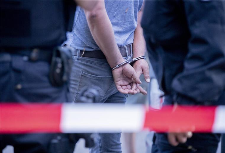 Eine mit Handschellen gefesselte Person steht am Rande einer Kundgebung gegen die Corona-Beschränkungen auf der Straße des 17. Juni neben Polizisten. Die Polizei hat die Veranstaltung aufgelöst. Zu der Demonstration gegen Corona-Maßnahmen hat die Initiative «Querdenken 711» aufgerufen. Das Motto der Demonstration lautet «Das Ende der Pandemie - Tag der Freiheit» +++ dpa-Bildfunk +++