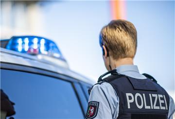 Polizistin neben Polizeiauto