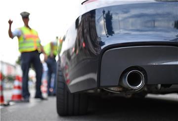 Ein Polizist in gelber Warnweste kontrolliert einen Pkw