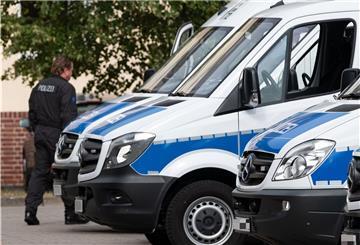 Polizeiwagen stehen nebeneinander. Ein Polizist geht an ihnen vorbei