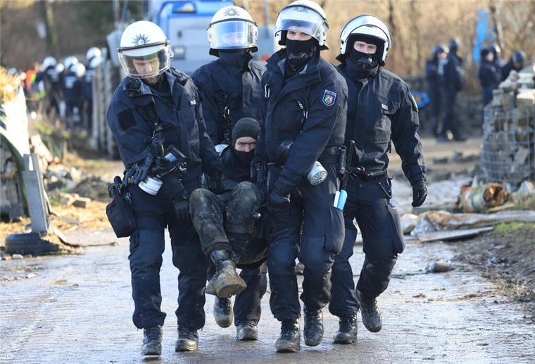 Bremen und Niedersachsen schicken Polizisten nach Lützerath Polizisten tragen einen Klimaaktivisten vom besetzten Braunkohleort Lützerath weg.