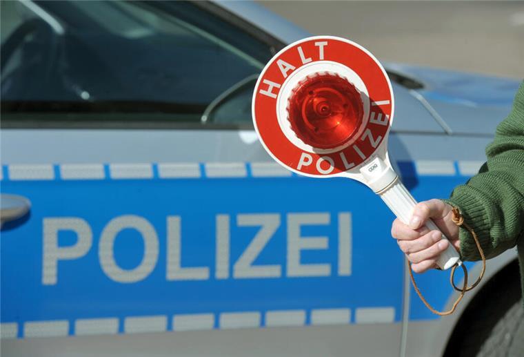 Da staunt selbst die Polizei: Autofahrer mit 3,6 Promille angehalten Eine Haltekelle wird von einem Polizisten vor einem Polizeifahrzeug.