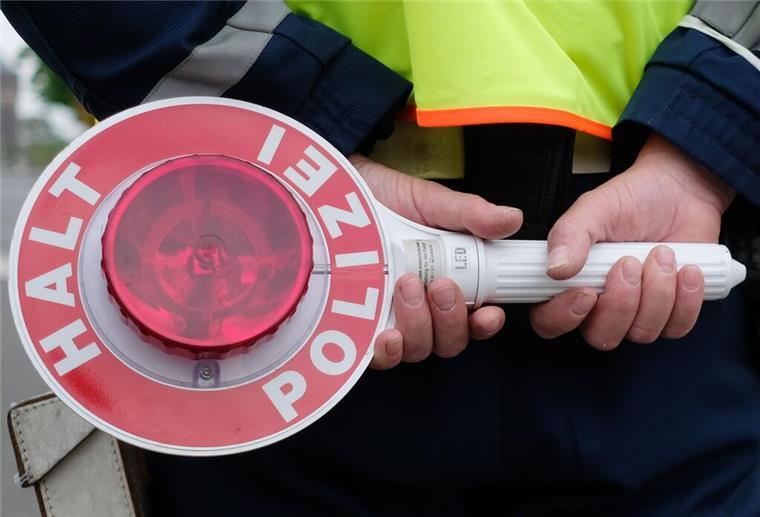 Ein Polizist während einer Verkehrskontrolle mit einer Haltekelle 