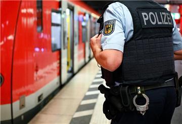 Ein Polizist steht an einem Bahnsteig.