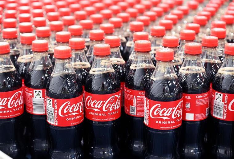 Änderung bei Coca Cola! Verbraucher müssen sich ab September umstellen Coca Cola Flaschen stehen auf einem Förderband.