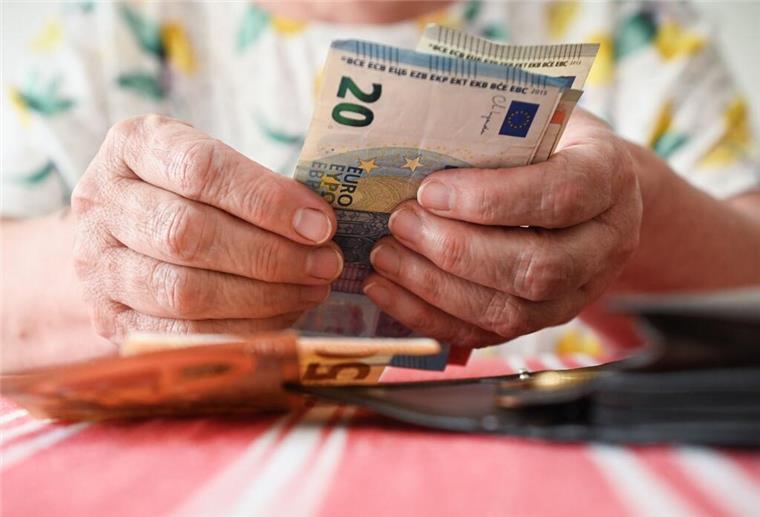 Eine ältere Person hält mehrere Geldscheine in die Kamera. Ein Auszahlungs-Service für die Rente wird noch dieses Jahr eingestellt. 