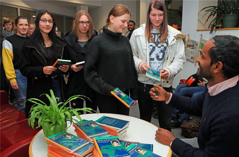Die Schüler des Gymnasiums standen Schlange, um sich ihre Bücher vom Autor signieren zu lassen.