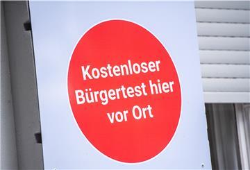 "Kostenloser Bürgertest hier vor Ort" steht an einem Covid-19-Testcenter.