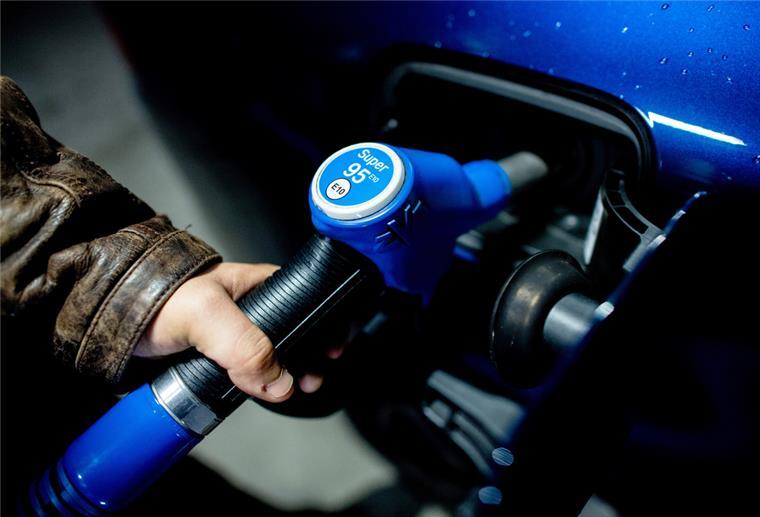 Ein Mann steckt kurz nach Mitternacht die Zapfpistole aus der Tanksäule an einer Tankstelle in sein Fahrzeug, um es mit Super E10 zum Preis von 1,799 Euro je Liter zu betanken. 