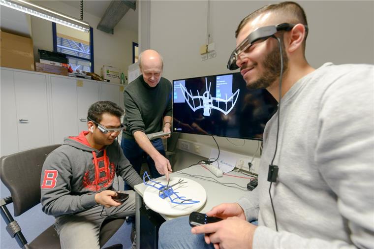 Hochschule in Bremerhaven lockt mit Bier und Apps Die Studenten Yuvakvechheka Som (links) und Dogan Bezek (rechts) bekommen von Prof. Dr. Thomas Umland VR-Brillen aufgesetzt - so können sie Objekte dreidimensional betrachten.