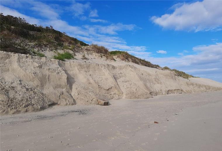 Festland und Inseln hängen mit Sturmflutvorbereitungen hinterher Abgebrochene Sanddüne