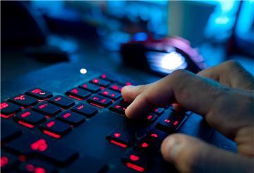  Ein Mann sitzt am Rechner und tippt auf einer Tastatur. 