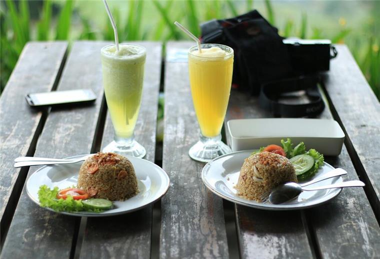 Mögliche Vorteile einer veganen Ernährung gebratener Reis und ein Glas Säfte auf dem Tisch.