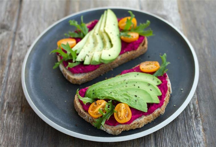 Mögliche Vorteile einer veganen Ernährung zwei geschnittene Brote mit Avocado oben drauf