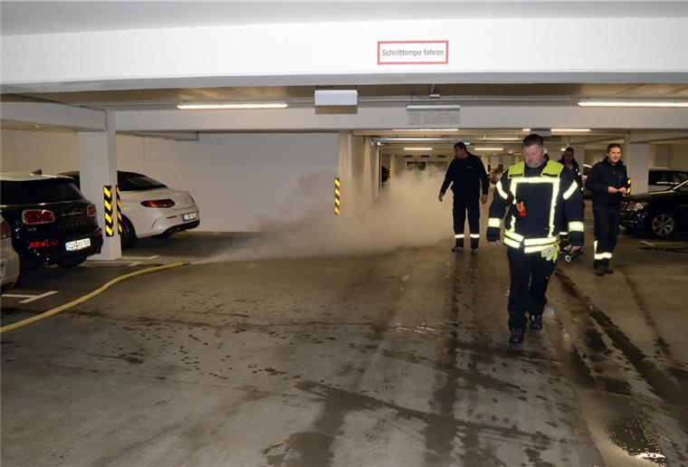 Die von Ortsbrandmeister Michael Wilcks (vorne) und anderen Feuerwehrleuten vorbereitete Verrauchung der Tiefgarage beginnt