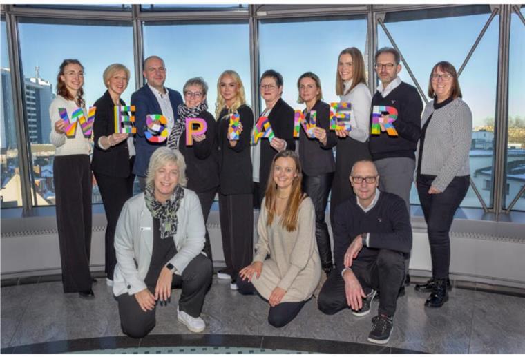 Komm ins #teamWESPA Gruppenfoto der Weser-Elbe Sparkasse mit dreizehn Personen.