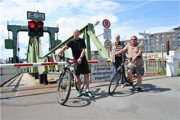 Die Weserfähre kann nicht fahren. Am Anleger in Bremerhaven stehen potenzielle Passagiere vor der verschlossenen Schranke.