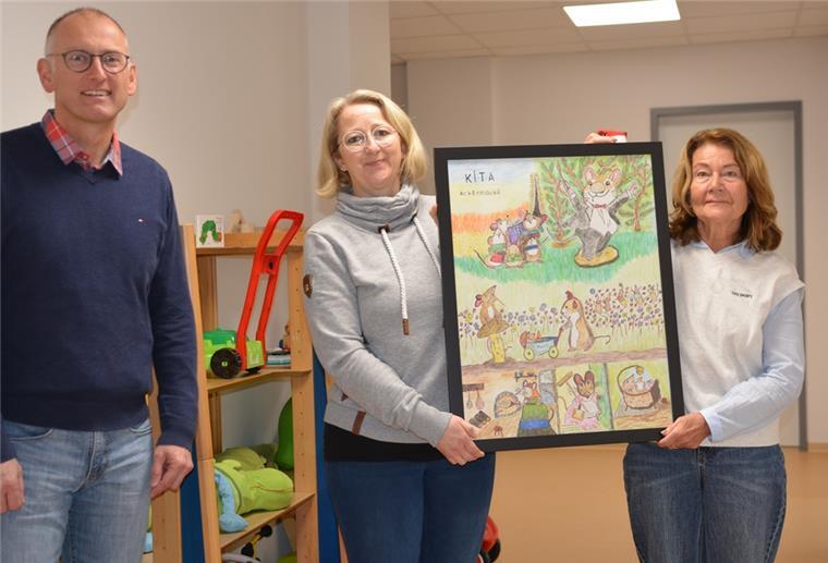 Gemeinde Loxstedt: Kunstwerke zieren Krippe und Kita Zwei Frauen halten ein Bild in die Höhe, ein Mann steht links daneben.
