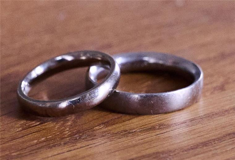 Tausende Bürger haben Anspruch auf Abfindung bei Witwenrente: Einfacher Antrag reicht Eheringe liegen auf einem Holztisch.
