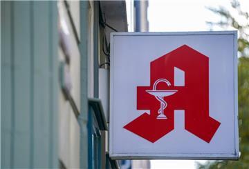 Ein Apotheken-Logo hängt an der Eingangsfassade einer Apotheke im Stadtteil St. Pauli.