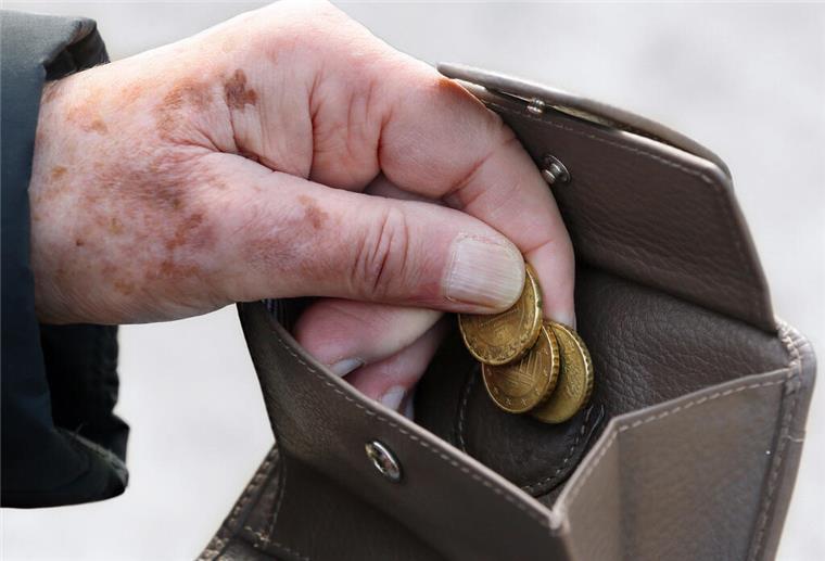 Altersarmut in Niedersachsen nimmt stark zu Eine Frau am holt Münzen aus ihrem Portemonnaie.