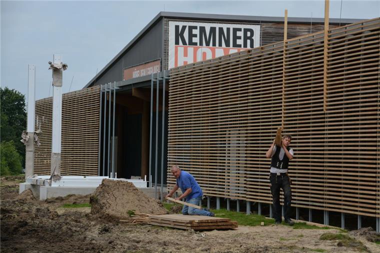 Die Zimmerleute haben schon ganze Arbeit geleistet. An der rückwärtigen Front des Möbelhauses ist die neue Lamellenstruktur gut zu erkennen, auch manche Pfeiler für die Werbe-Würfel stehen bereits.