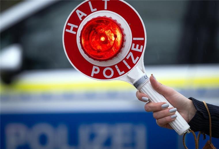 Was Du bei einer Verkehrskontrolle darfst – und was nicht Ein Polizist hält eine Polizeikelle für eine Kontrolle an der Autobahn.
