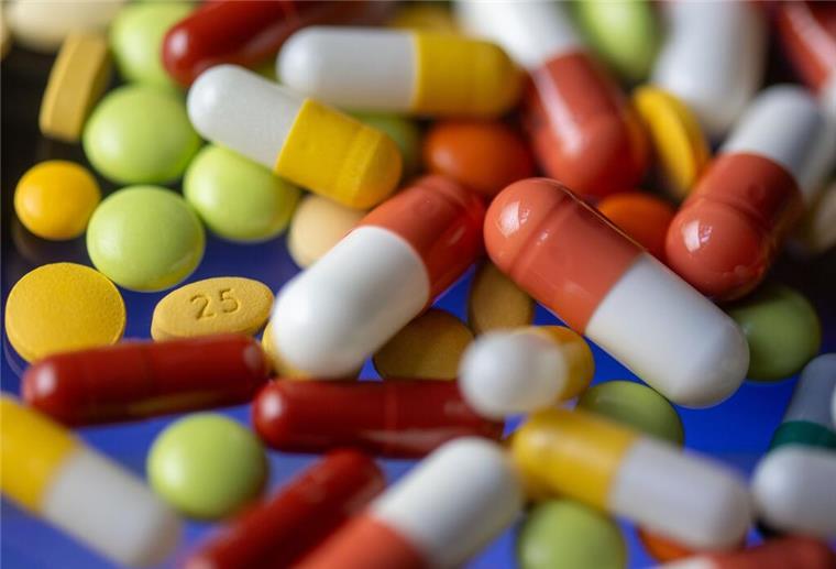 Verschiedene Tabletten, Kapseln und Dragees liegen auf einem Tisch.