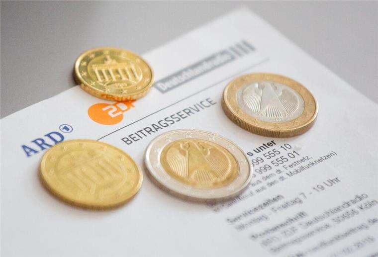 Das ist der Hammer! So einfach befreit ihr euch vom Rundfunkbeitrag Euromünzen liegen auf einem Anschreiben zur Anmeldung für die Rundfunkgebühren, neben dem Logo von ARD (l-r), ZDF und Deutschlandfunk.