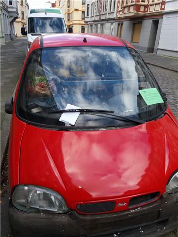 Diese rote Auto steht ohne Kennzeichen, dafür aber bis obenhin zugemüllt vor der...