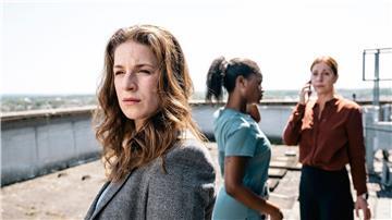 Dina Schwarz (Lou Strenger, links) blickt zu dem am Dach-Rand stehenden Nathan Freye. Im Hintergrund rufen Veronika Jelinek (Ulrike Tscharre, rechts) und Jenny de Luca (Melodie Simina, Mitte) Hilfe.