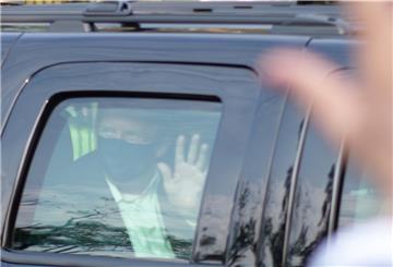 Donald Trump fährt in einem SUV an seinen Anhängern vorbei.