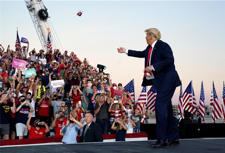 Trump steht auf einer Bühne vor Publikum. 