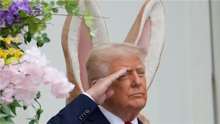 Donald Trump steht vor einem großen Osterhasen - und es sieht so aus, als hätte er sich die Ohren geliehen.