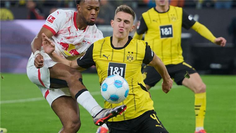 Dortmund schlägt Leipzig - Kiel feiert Premierensieg Dortmunds Nico Schlotterbeck und Lois Openda (l) von Leipzig kämpfen um den Ball und den Sieg im Topspiel.