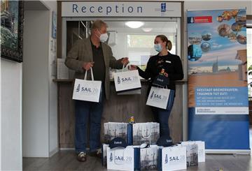 Dr. Ralf Meyer übergibt Hotelmanagerin Ann-Christin Heins von der Seemannsmission Sail-Souvenirs, um die dort betreuten Seeleute zu erfreuen. 