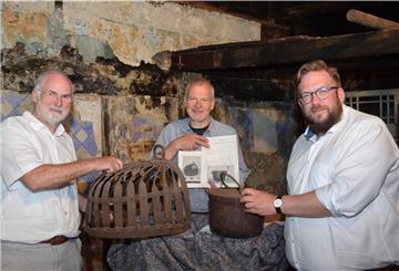 Dr. Wolfgang Dörfler (links) und Hans-Hermann Bohling (Mitte) von der Interessengemeinschaft Bauernhaus freuen sich über den Feuerstülper und den Kessel, als Dauerleihgabe überlassen für "Eckes Hus" in Ostereistedt.