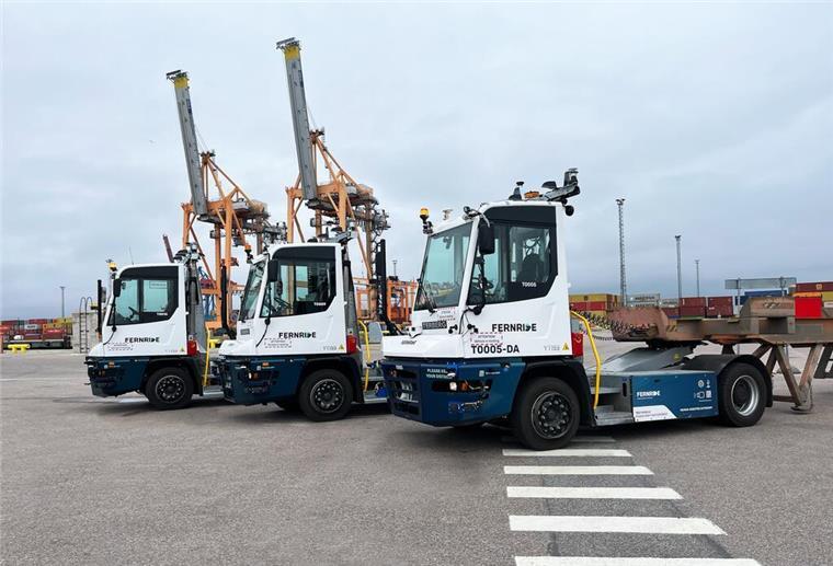 Fernride startet mit fahrerlosen Zugmaschinen an Terminal in Estland Drei autonome Terminal-Zugmaschinen von FERNRIDE stehen nebeneinander auf einem Containerterminal, im Hintergrund Container und Hafenkräne.
